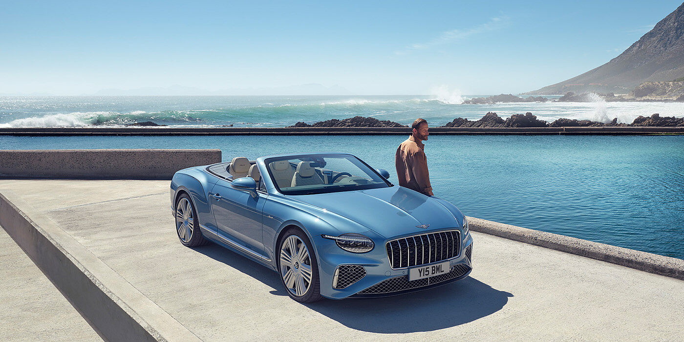 Bentley Essex (Chelmsford) New Bentley Continental GTC Azure convertible front view in Light Windsor blue paint with 22 inch ten spoke wheels parked by the sea in the sunshine