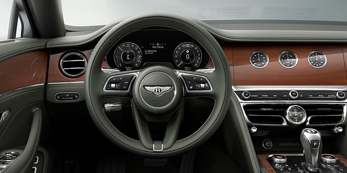 Bentley Essex (Chelmsford) New Bentley Flying Spur sedan front cabin in Cumbrian Green hide and Crown Cut walnut veneer showing steering wheel and Rotating Display with three clocks on face
