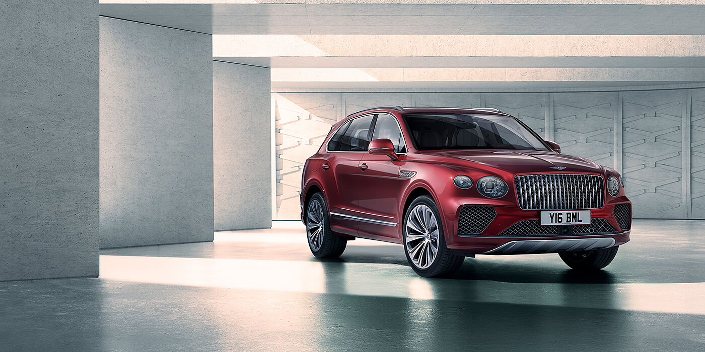 Bentley Essex (Chelmsford) Bentley Bentayga Atelier Edition SUV in Rubino Red paint front three quarter against textured concrete wall
