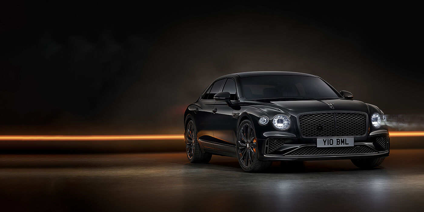 Bentley Essex (Chelmsford) Bentley Flying Spur Black Edition sedan in Black Crystal paint against a dark grey and copper coloured background