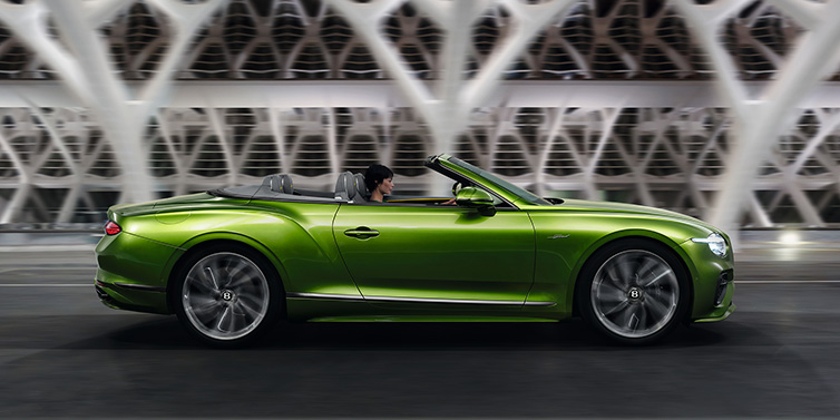 Bentley Essex (Chelmsford) Bentley Continental GTC Speed convertible side profile in Tourmaline Green paint driving dynamically on a bridge at night