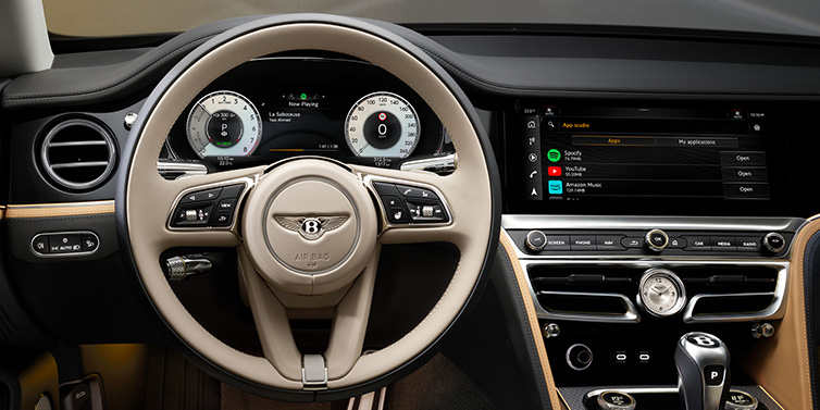 Bentley Essex (Chelmsford) Bentley Flying Spur Mulliner sedan front interior detail of steering wheel and driver screens surrounded by Linen and Beluga black hides